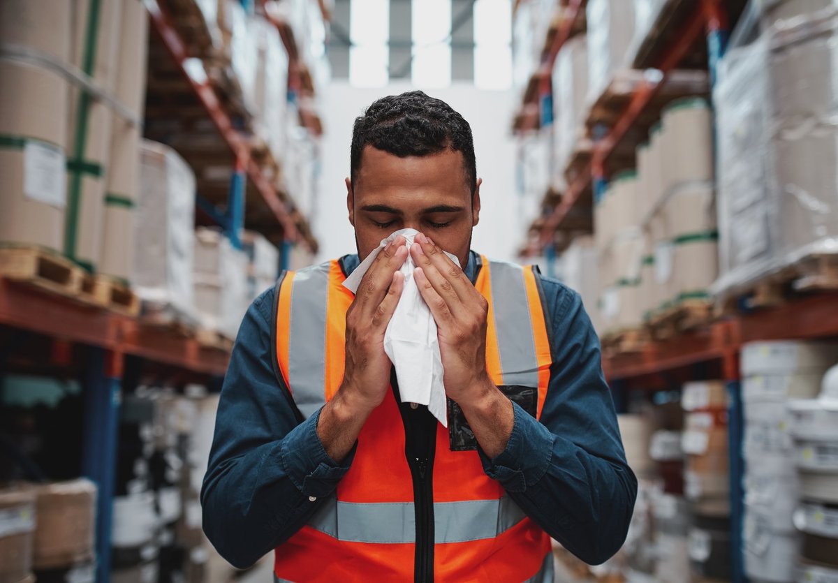 blue collar worker blowing nose