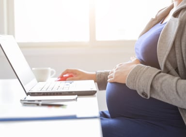 pregnant person on computer