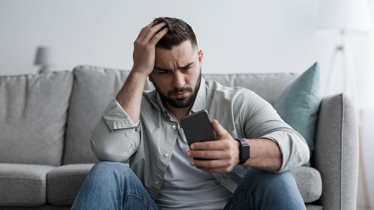 Stressed man looking at his phone