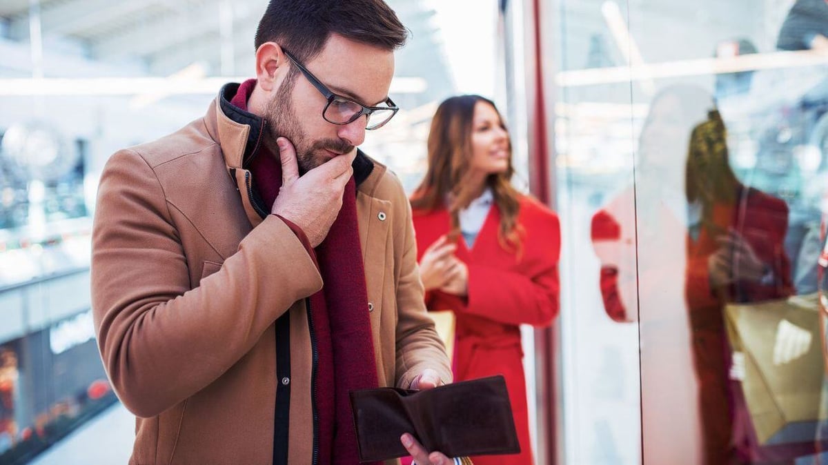 Man looking at empty wallet